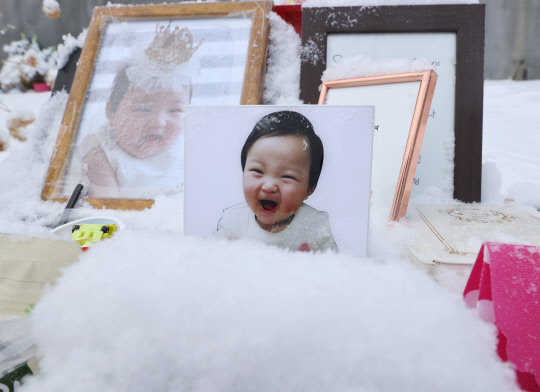 정인이를 추모하며      (양평=연합뉴스) 서명곤 기자 = 13일 오전 경기도 양평군 하이패밀리 안데르센 공원묘원에 양부모의 학대로 생후 16개월 만에 숨진 정인 양의 사진이 놓여있다.      서울남부지법 형사13부는 이날 아동학대범죄의처벌등에관한특례법 위반(아동학대치사) 등 혐의로 구속기소 된 양모 장 모 씨의 첫 공판을 연다. 2021.1.13      seephoto@yna.co.kr  (끝)